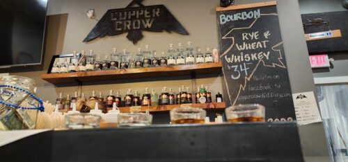 View of the tasting bar at Copper Crow Distillery near Bayfield, with a spirit flight in the foreground.